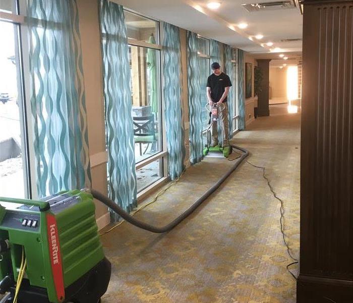 SERVPRO technician extracting water from a carpet