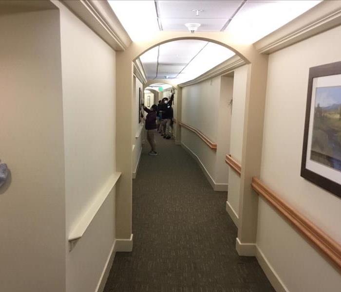 SERVPRO team cleaning a hotel hallway